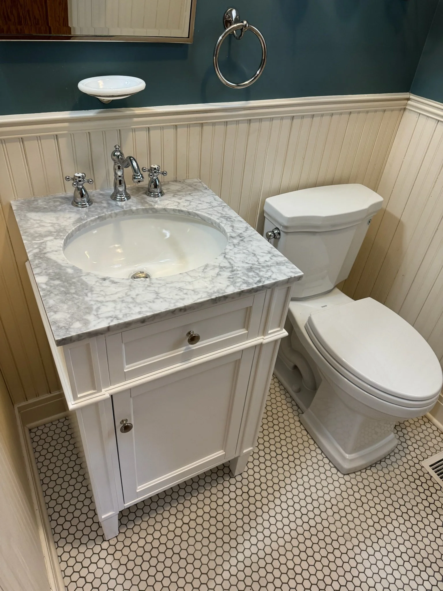 Bathroom vanity with a marble-pattern countertop and chrome faucet.