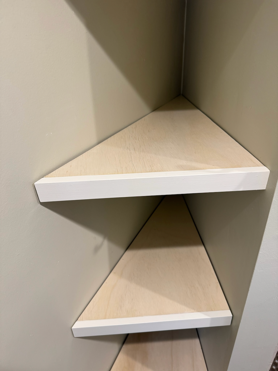 Close view of the fitted triangular closet shelves.