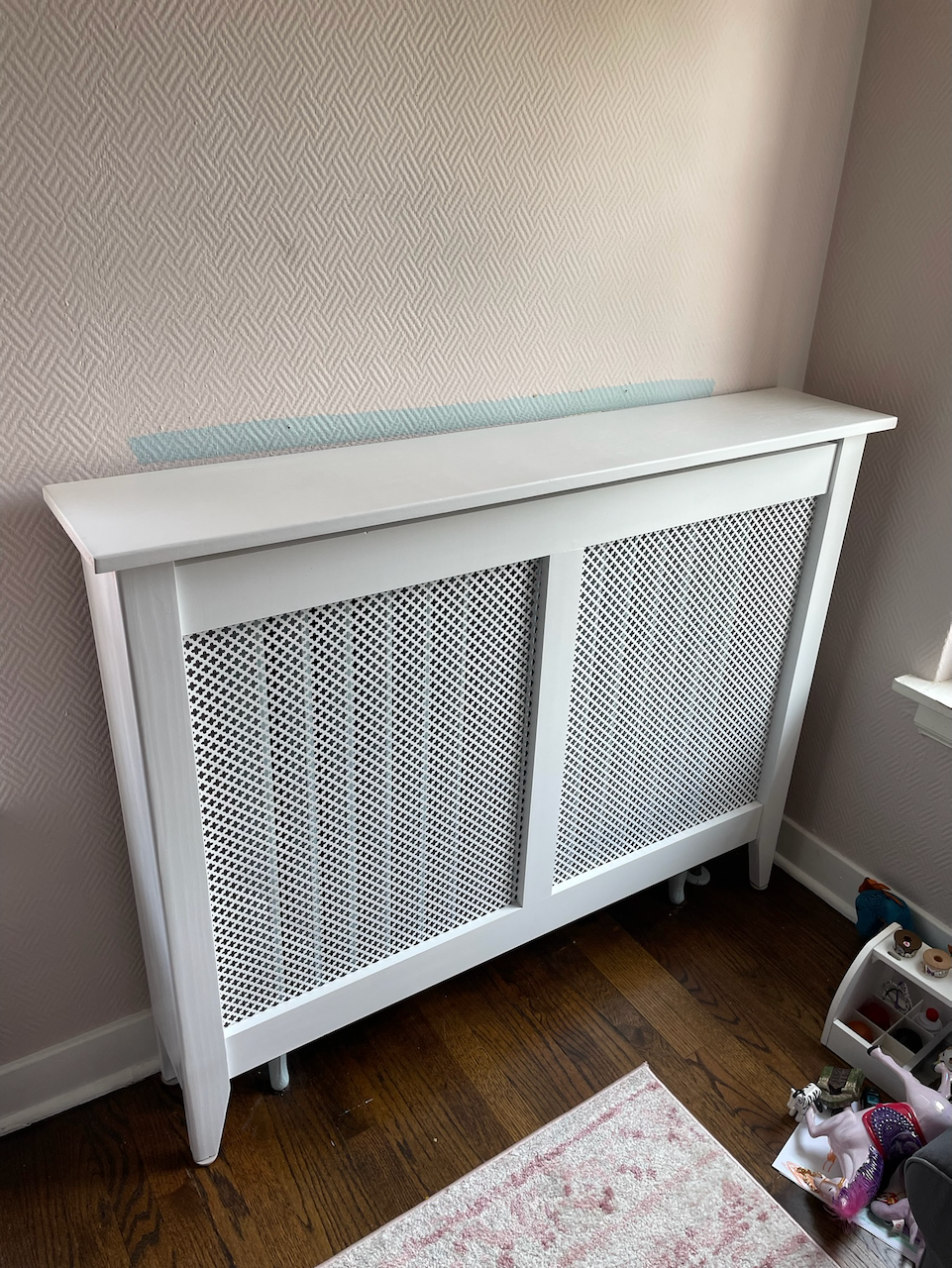 Angled view of the custom radiator cover, showing the fitted side panel and raised feet.