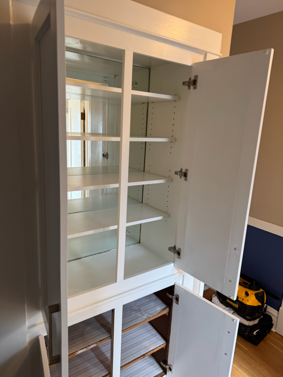 White linen cabinet with interior storage.