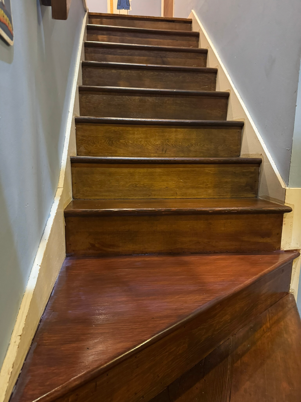 Restored wood treads along the straight stair flight.