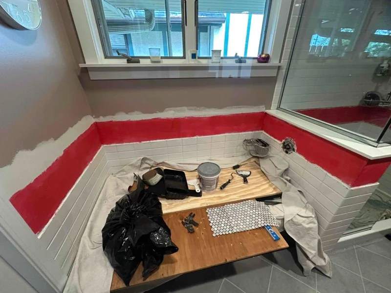 Bathroom tile replacement in progress beneath the window