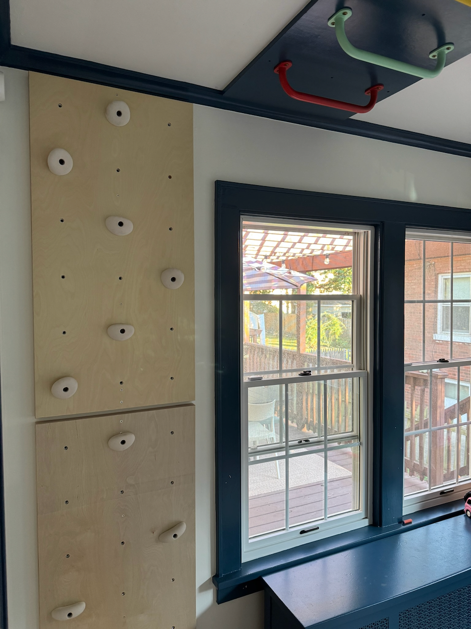 Climbing wall with holds and matching blue room trim.