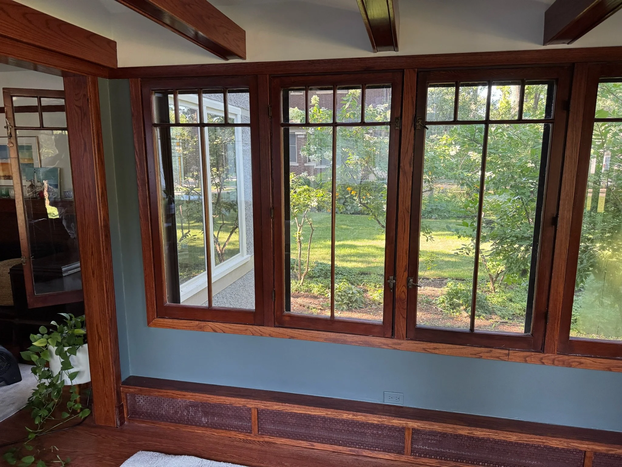 Finished wall repairs around the wood-framed windows, viewed across the room.