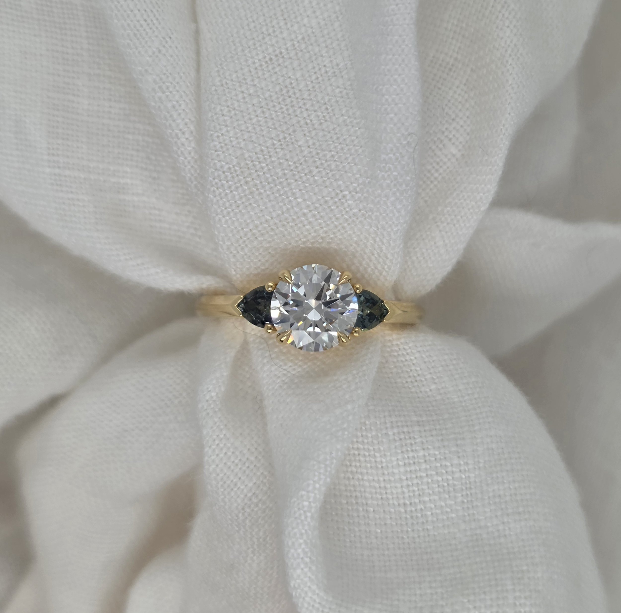 Round Brilliant Cut Diamond with Trilliant Cut Green/Blue Sapphires Engagement Ring