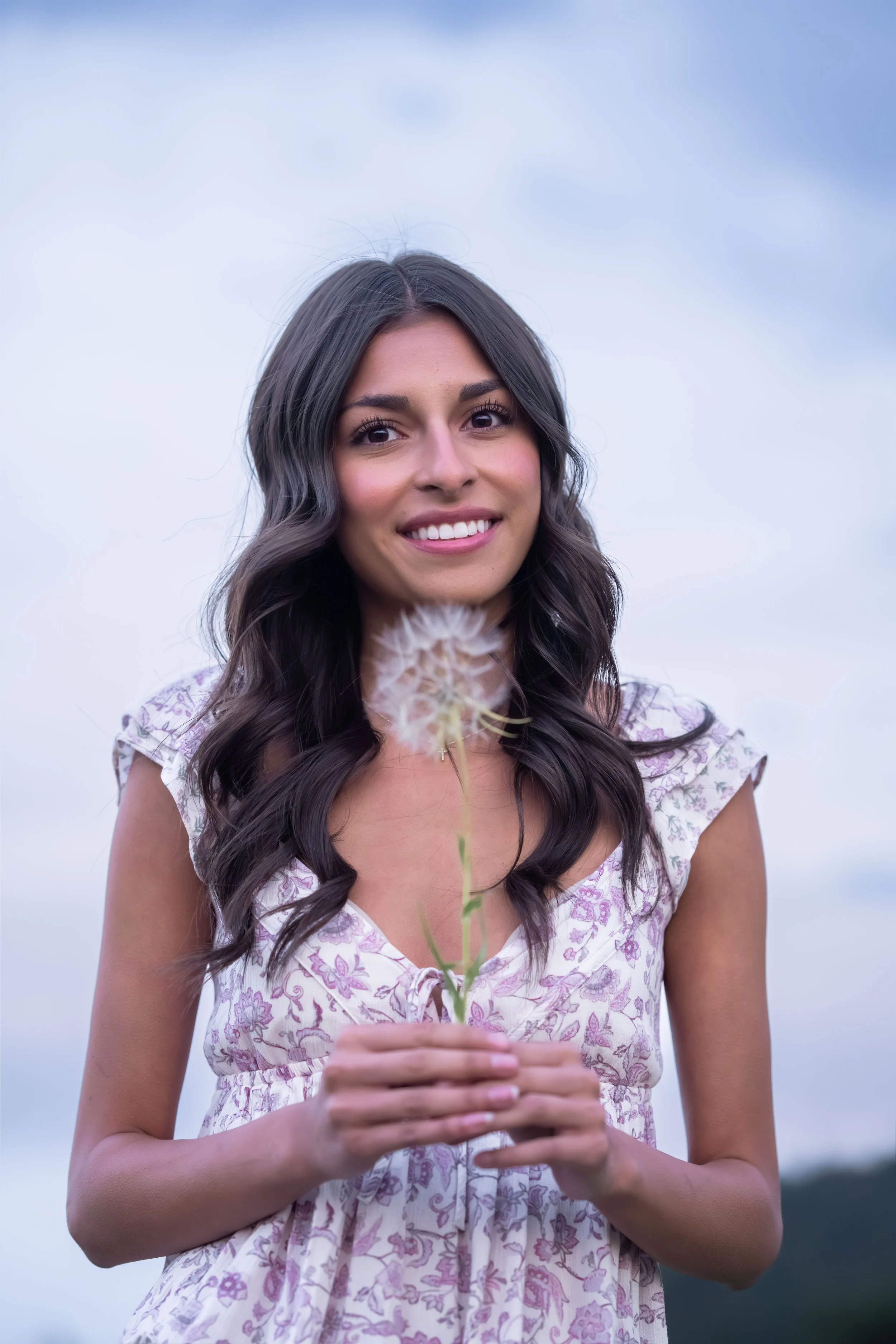 High school senior from Arvada holds a dandelion on White Ranch Park. 