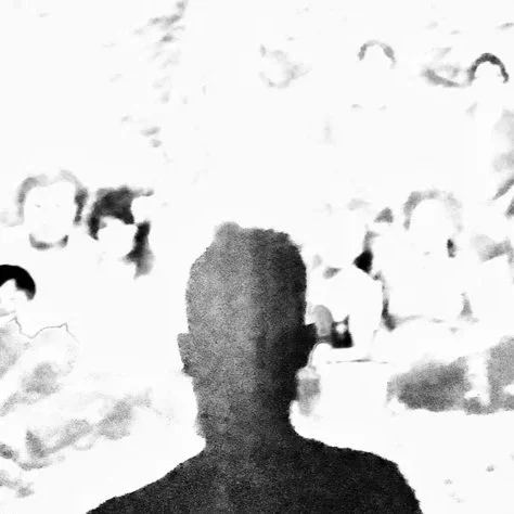 A figure among a shadow of faces