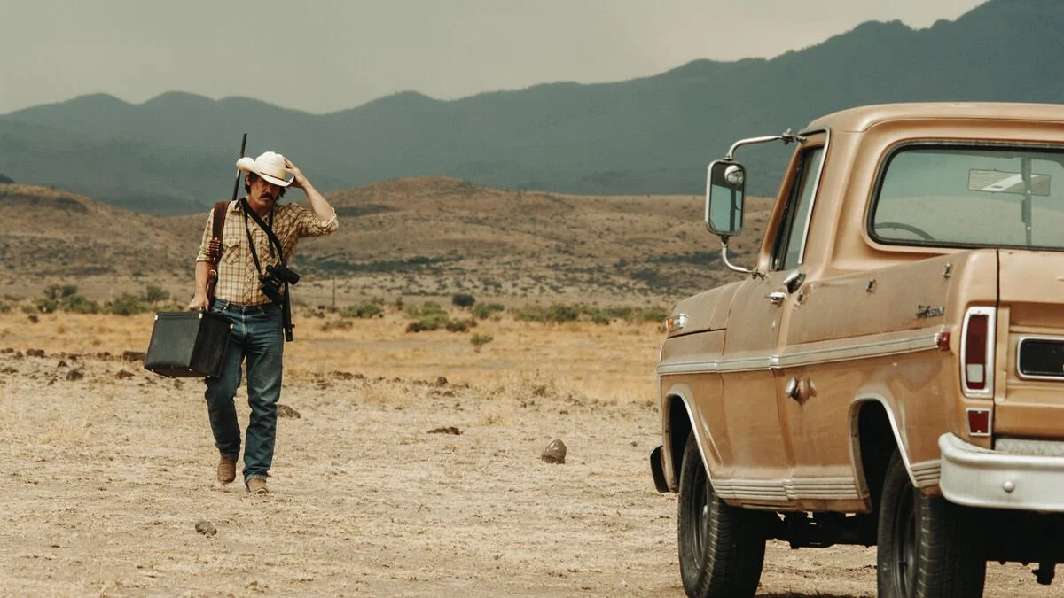 A man walking towards a truck in the desert