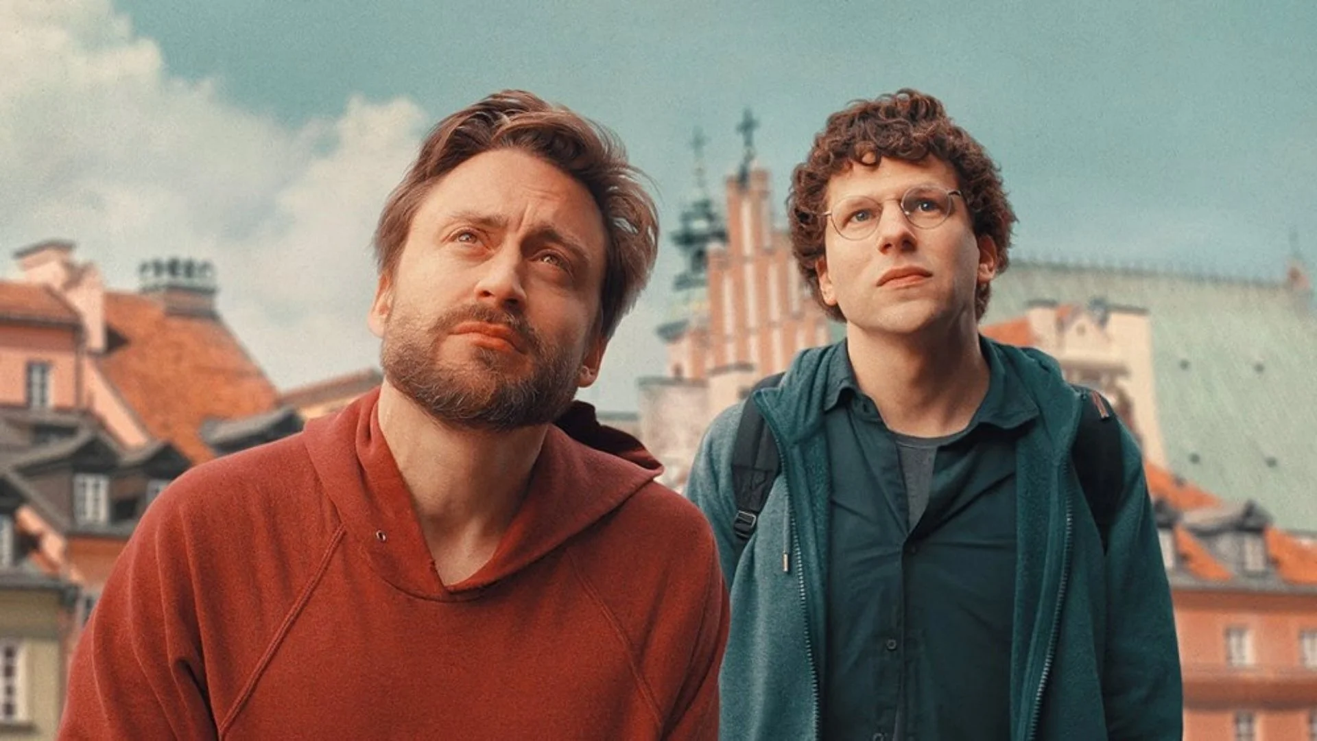Two men gazing forward in front of a town
