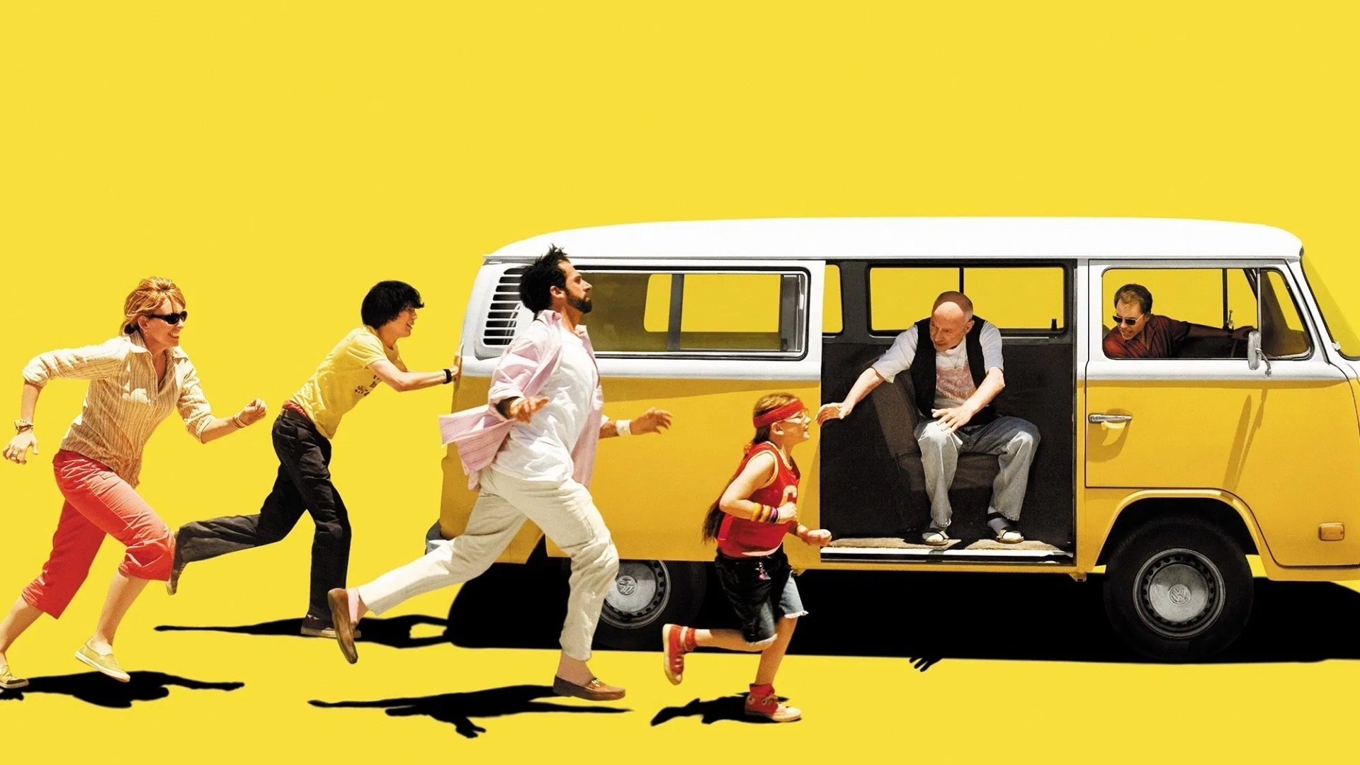 A group of family members chase a yellow VW minibus