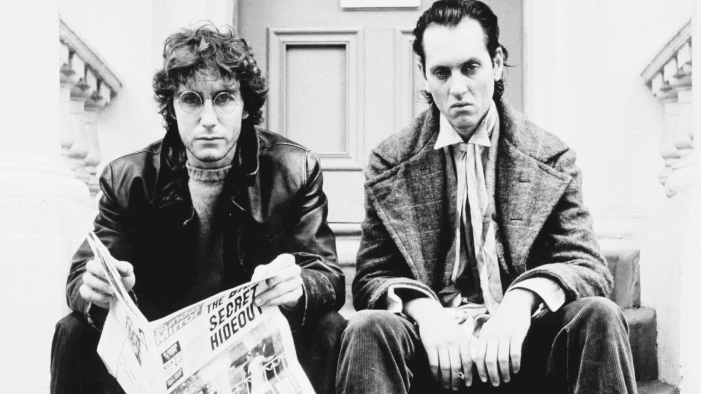 Two men sit on a step and look miserable