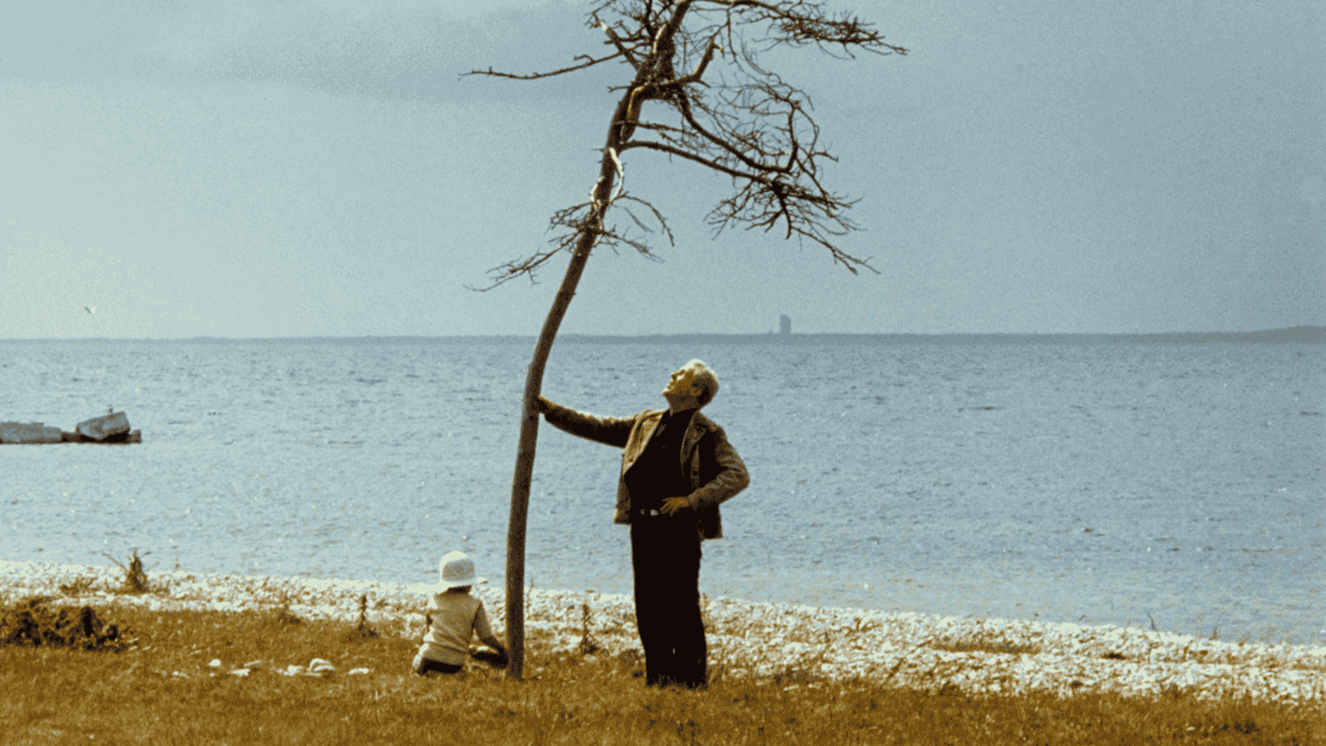 A man and a boy standing in front of a tree
