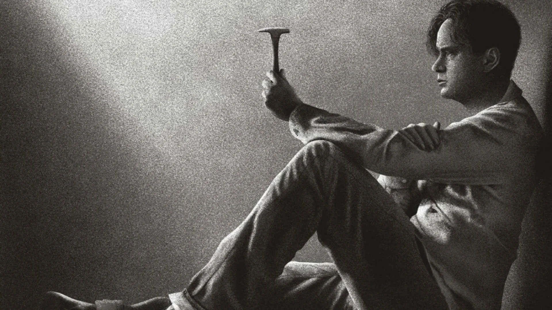 An artwork of a man sitting against a wall with a small rock hammer in his hand