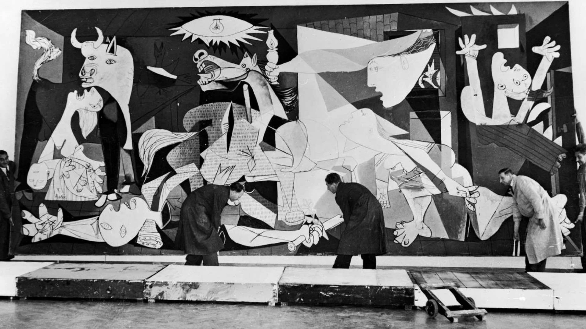 Men inspect Picasso's painting of Guernica