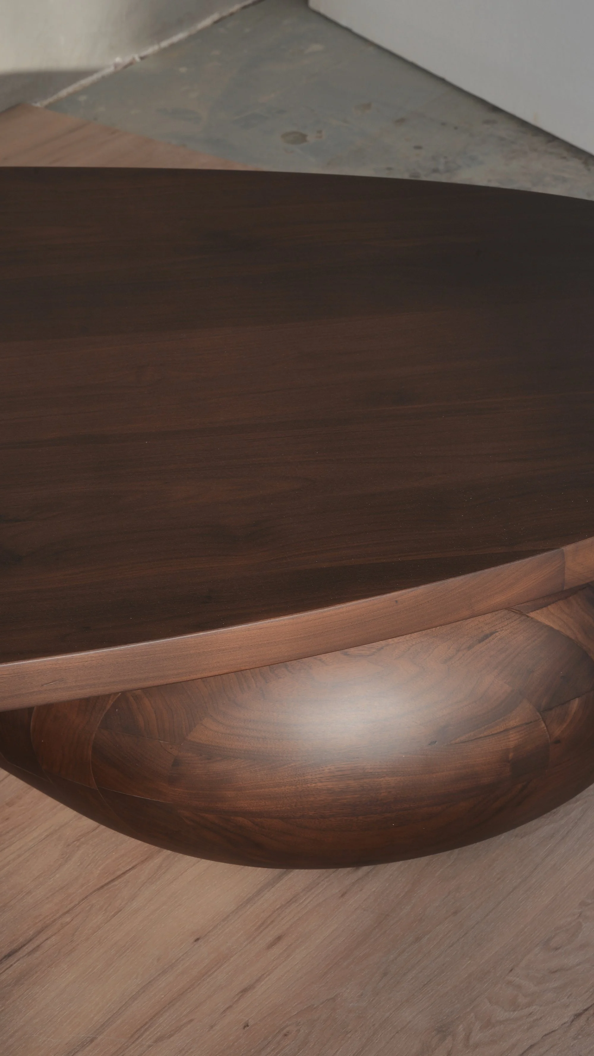 Walnut Sereno coffee table with massive sculptural legs that lift the top, creating a floating effect.