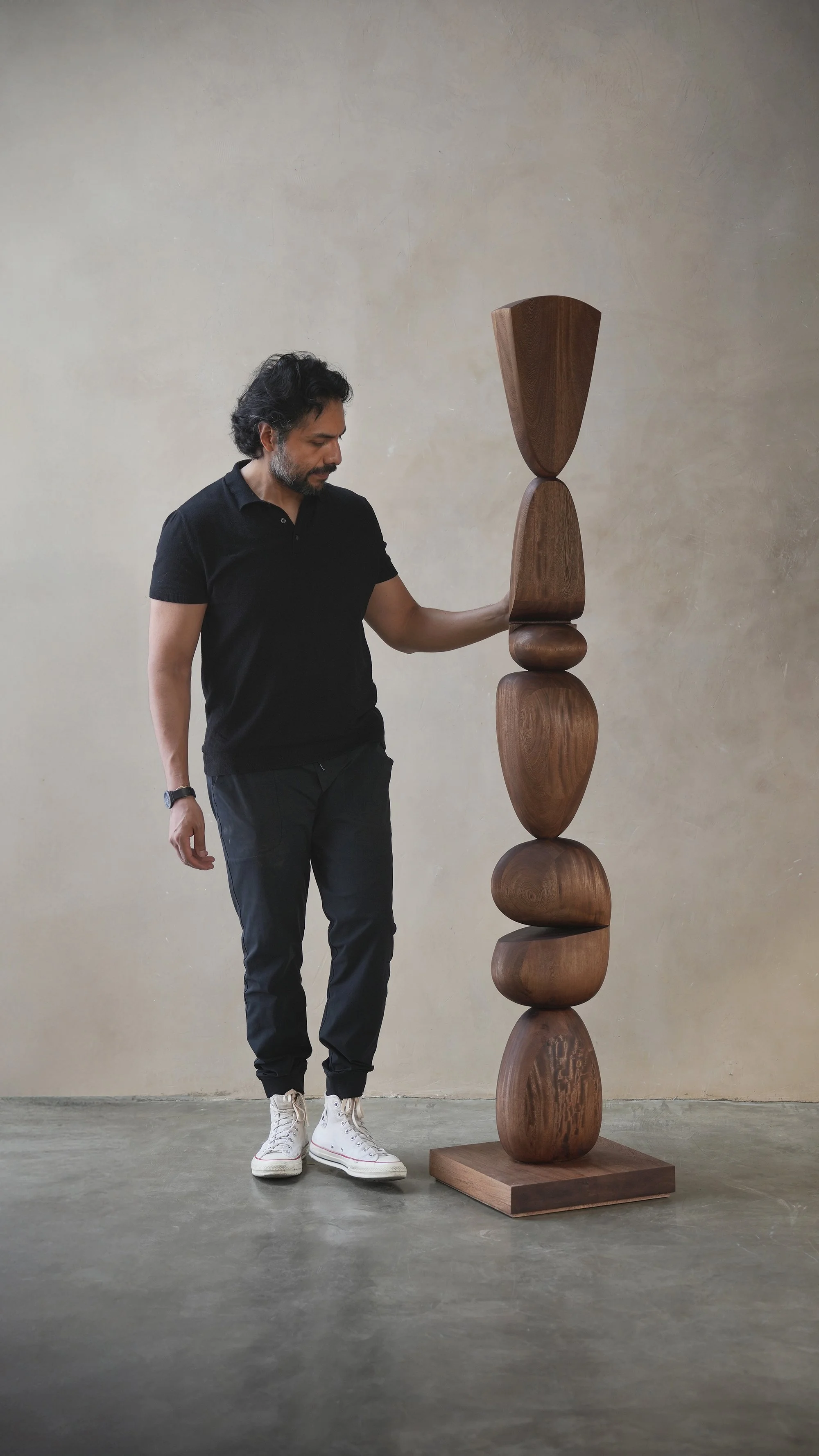 Wooden standing sculpture with irregular stacked forms and visible wood grain.