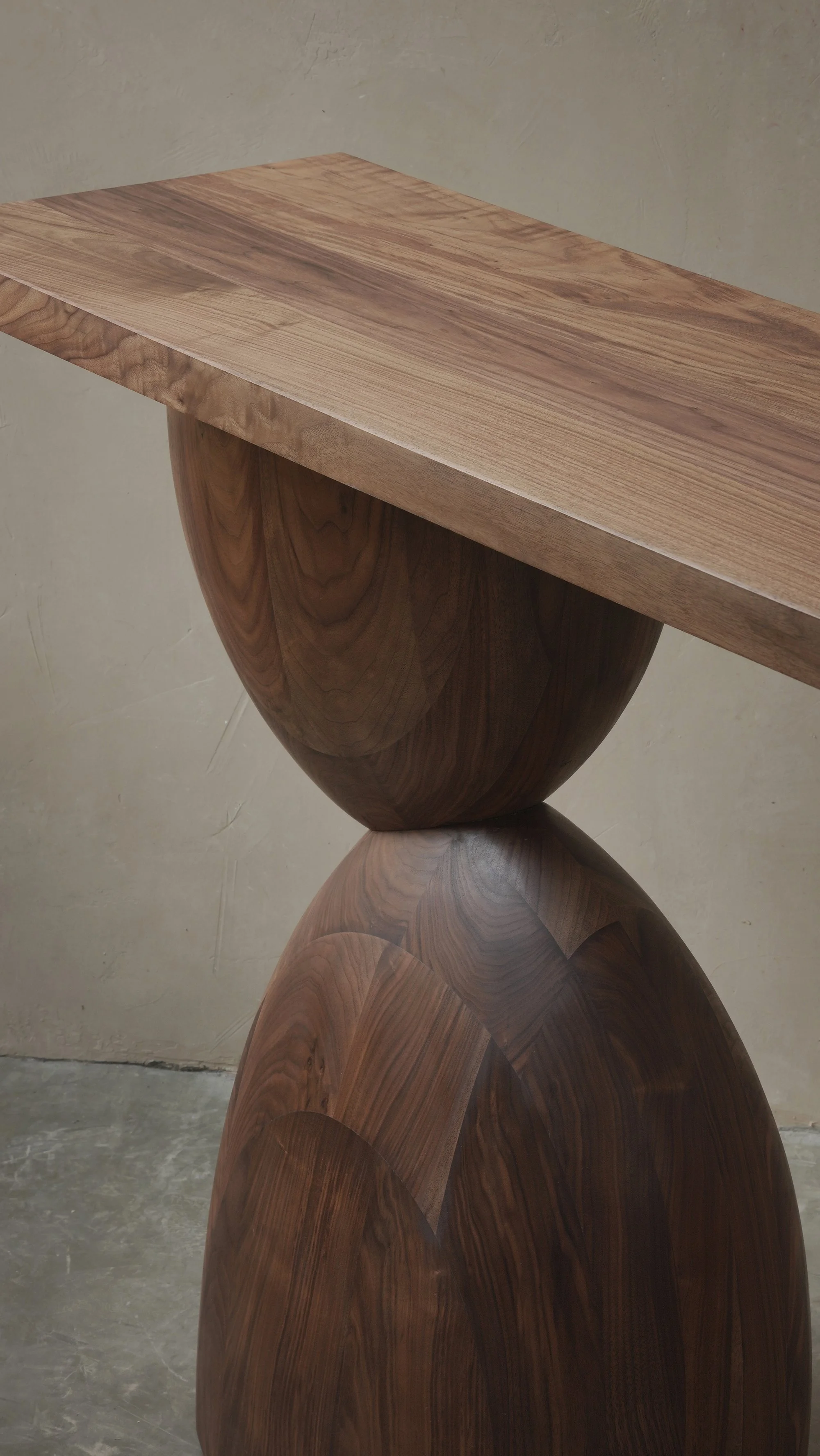 Elefante console table with stacked, asymmetrical walnut volumes.