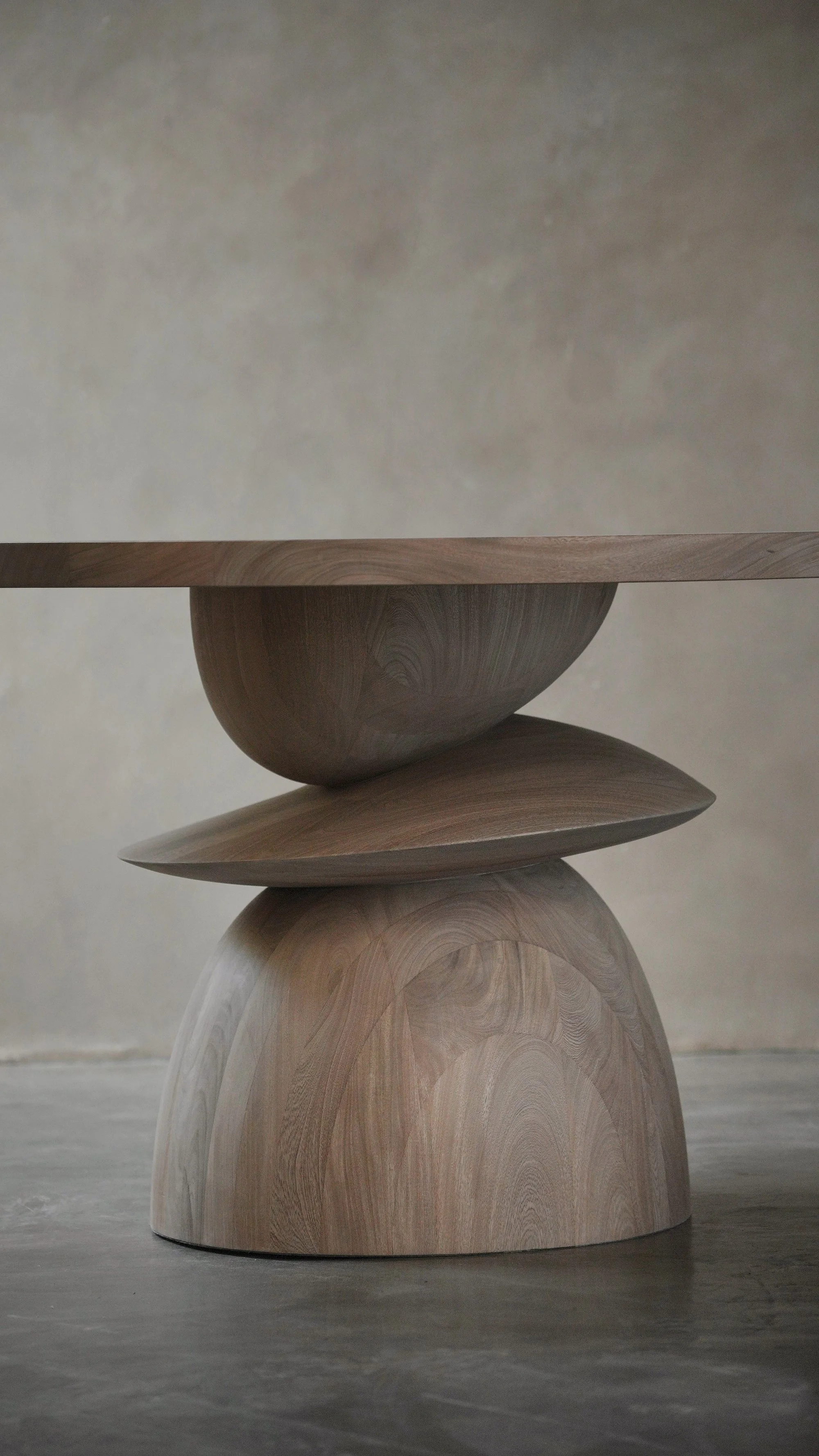 Sculptural dining table featuring an expressive plinth-style wooden base.
