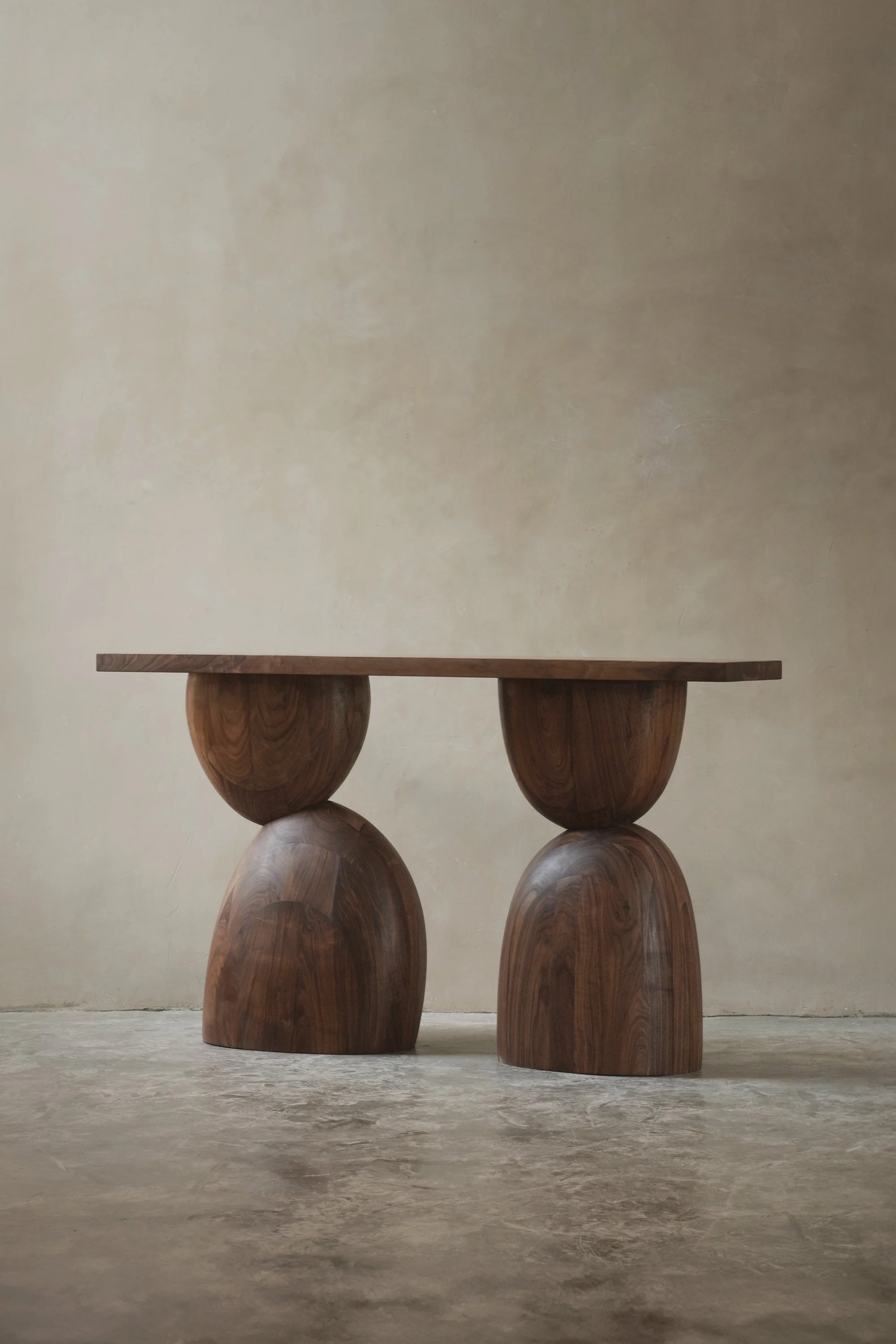 Elefante console table with stacked, asymmetrical walnut volumes.