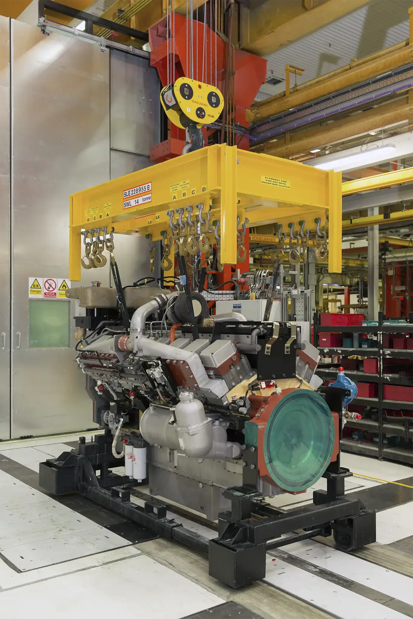 A large industrial piece of equipment in a manufacturing or testing facility, with machinery and overhead crane system.