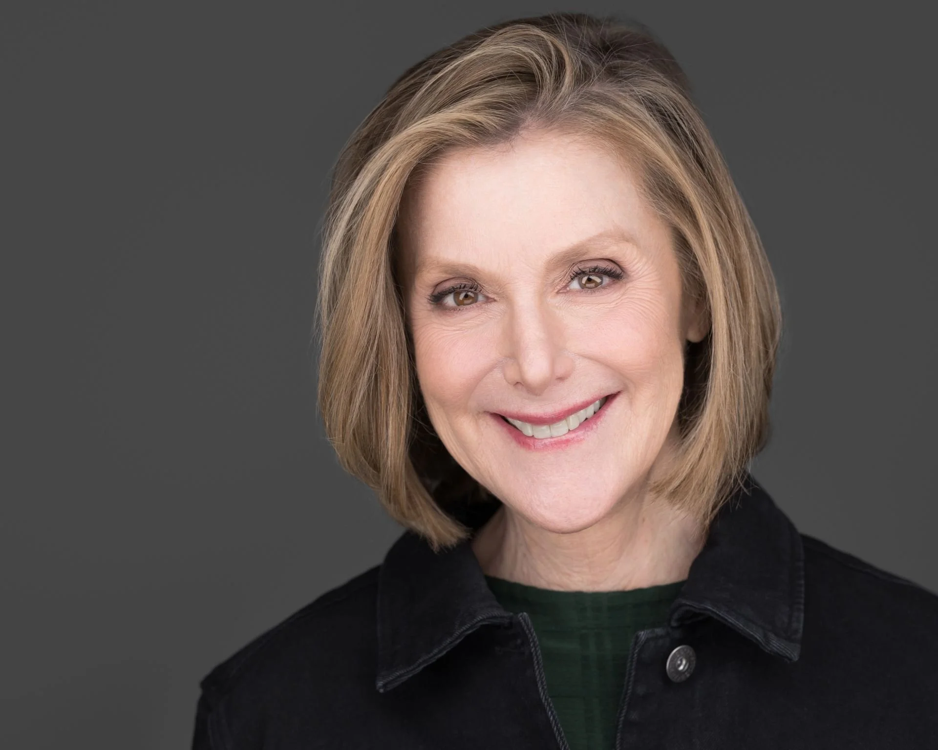Headshot of Robin Merle in a green sweater and black denim jacket.