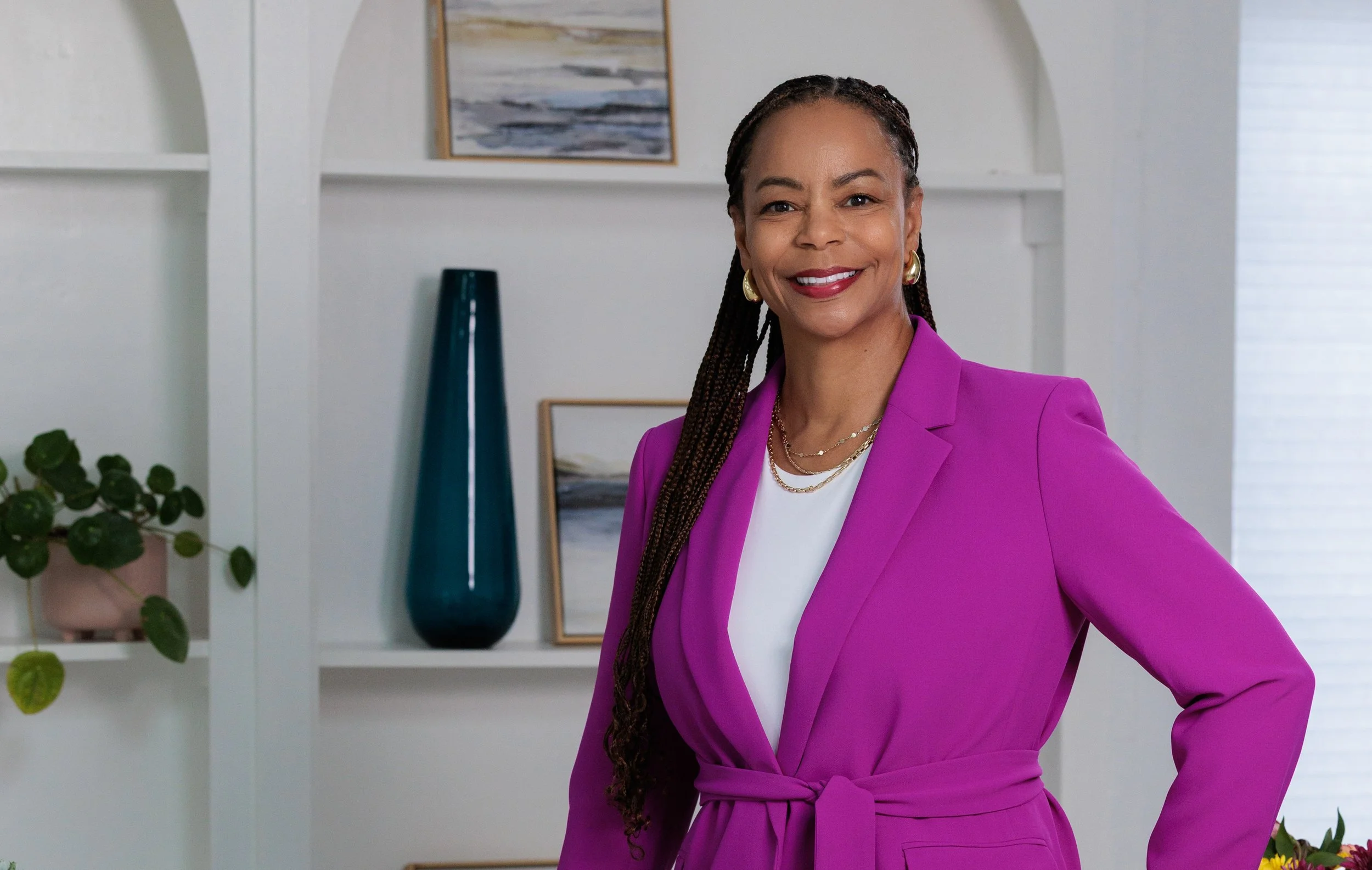 African American woman with long braids in fuschia business suit