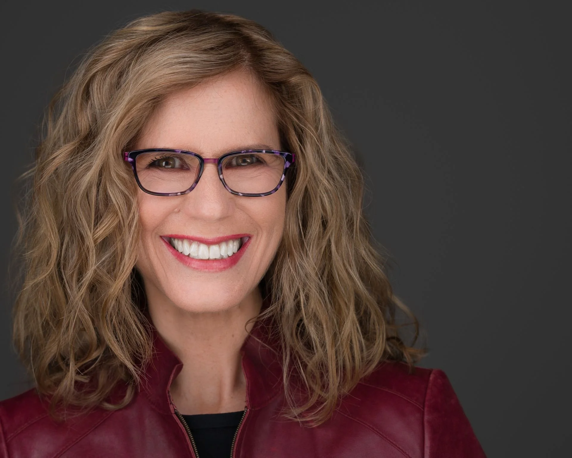 Blonde Exeutive Lady with Tortoise-shell glasses smiling