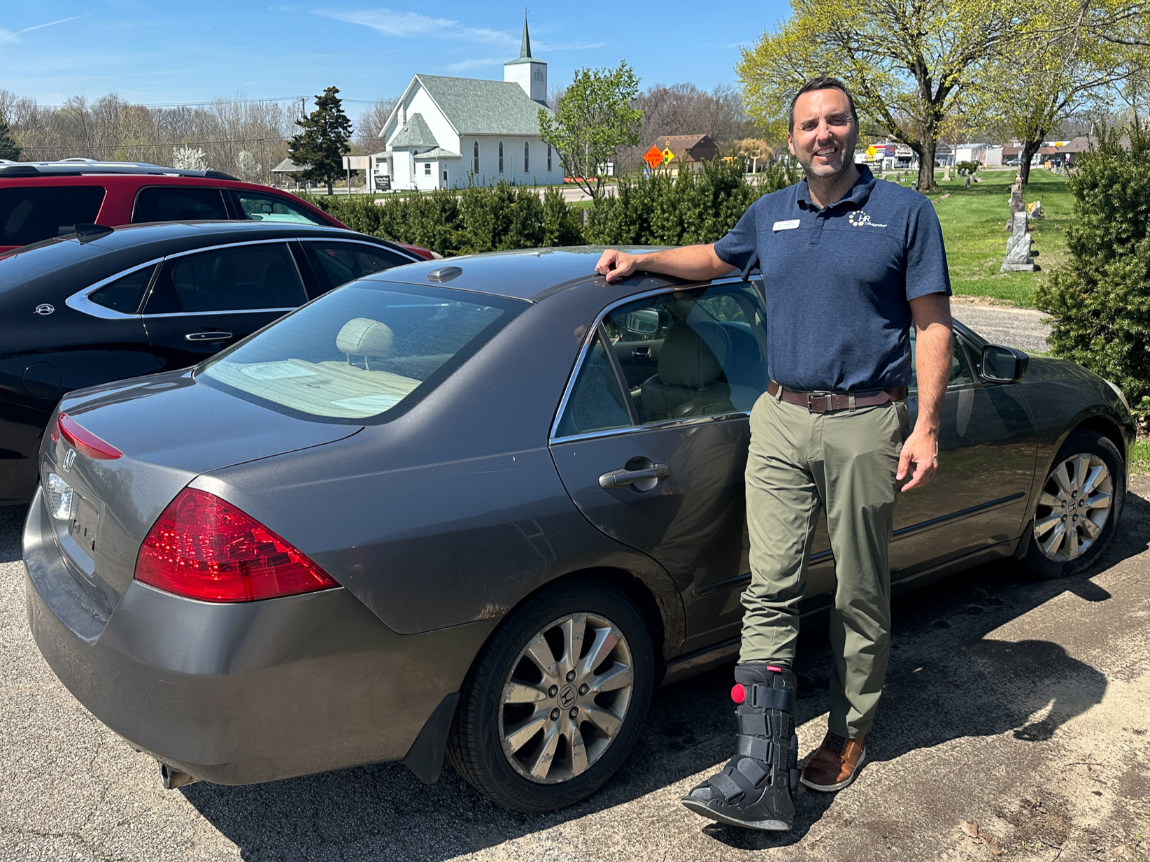 Man standing next to donated Honda Accord.