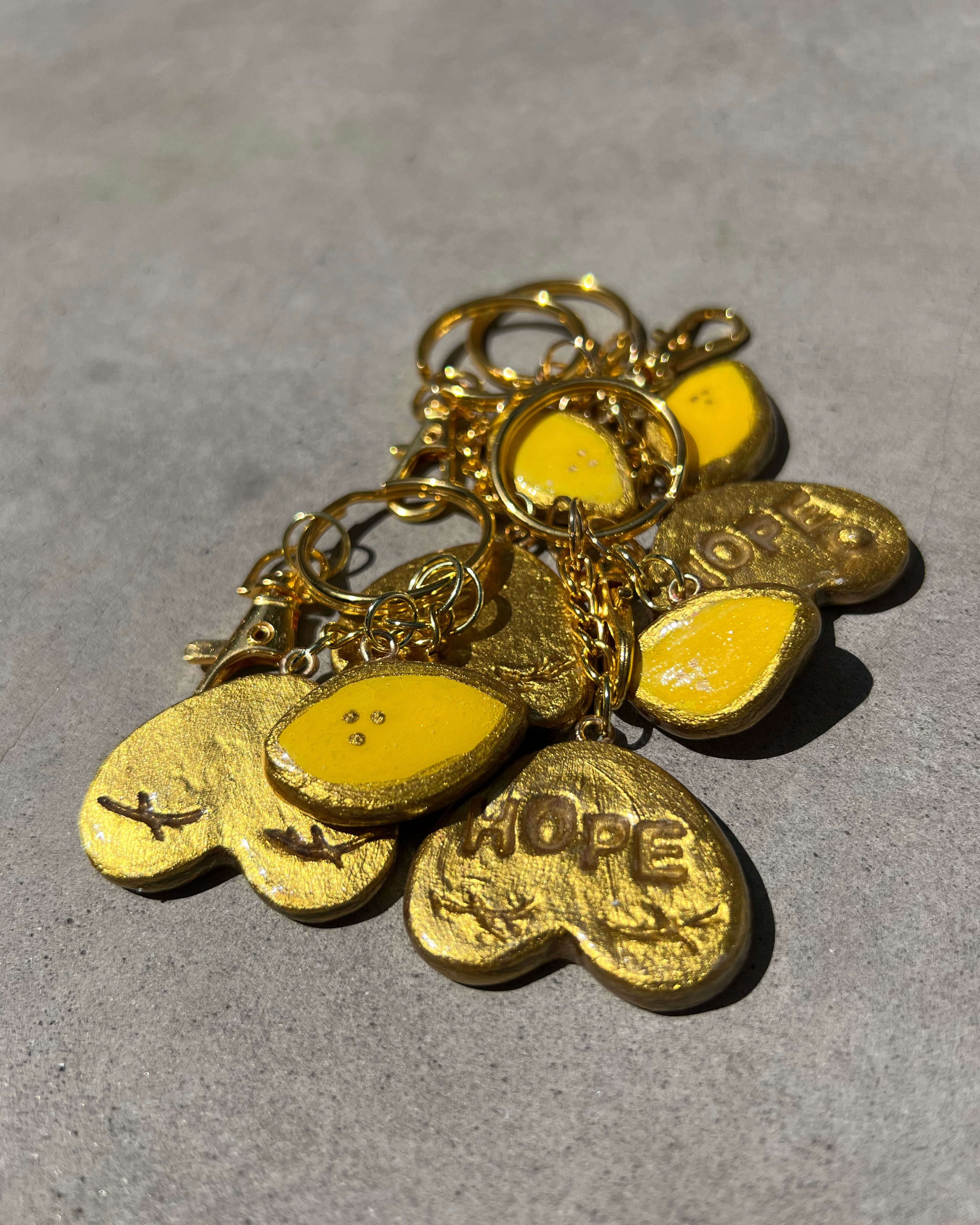 Group photo of gold boob keychains with lemon charms