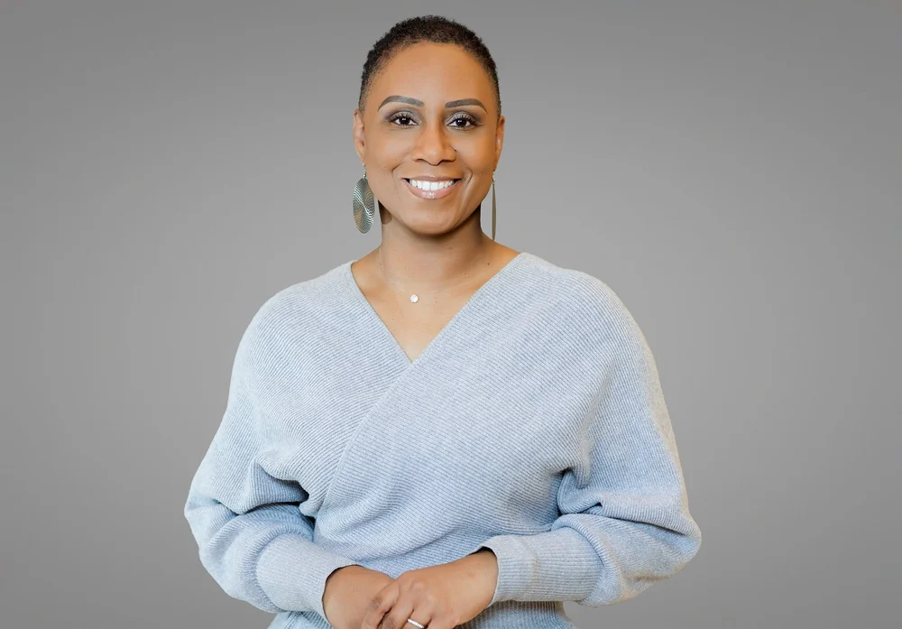 Team and staff headshot of a smiling New York professional in a light blue sweater, by Blue Sky's Studio