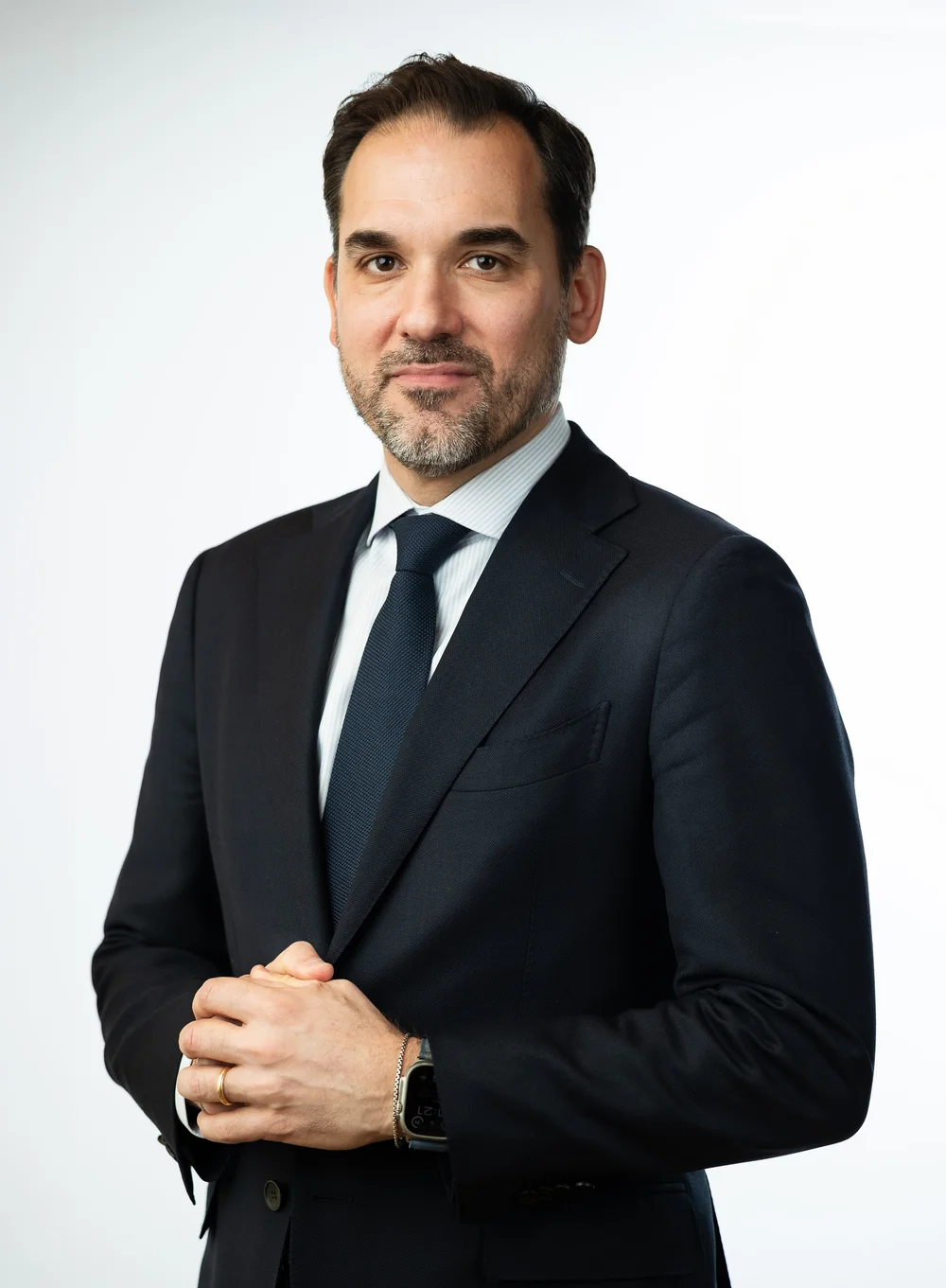 Law firm partner headshot of a man in a dark suit and tie on a white background