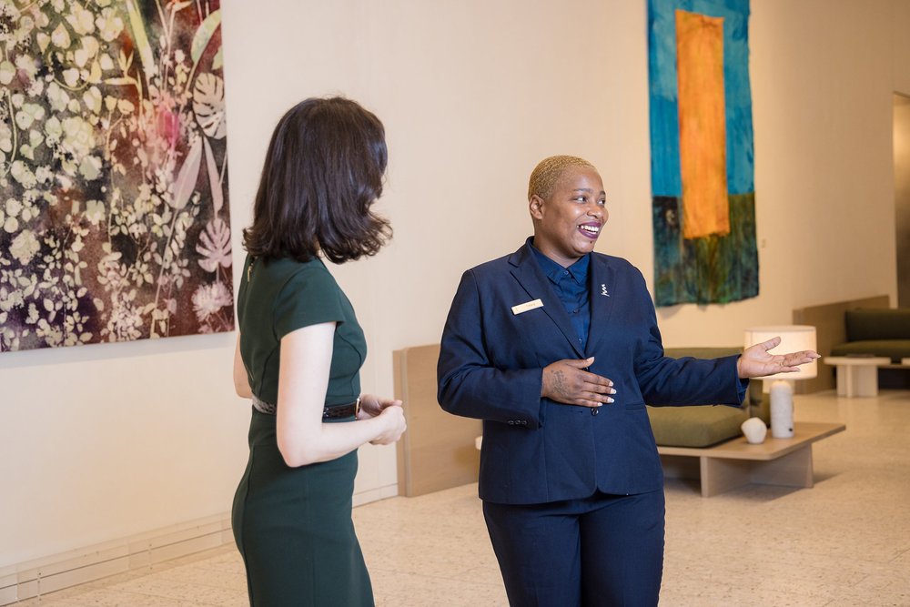 Two women in conversation in a modern workspace with colorful artwork