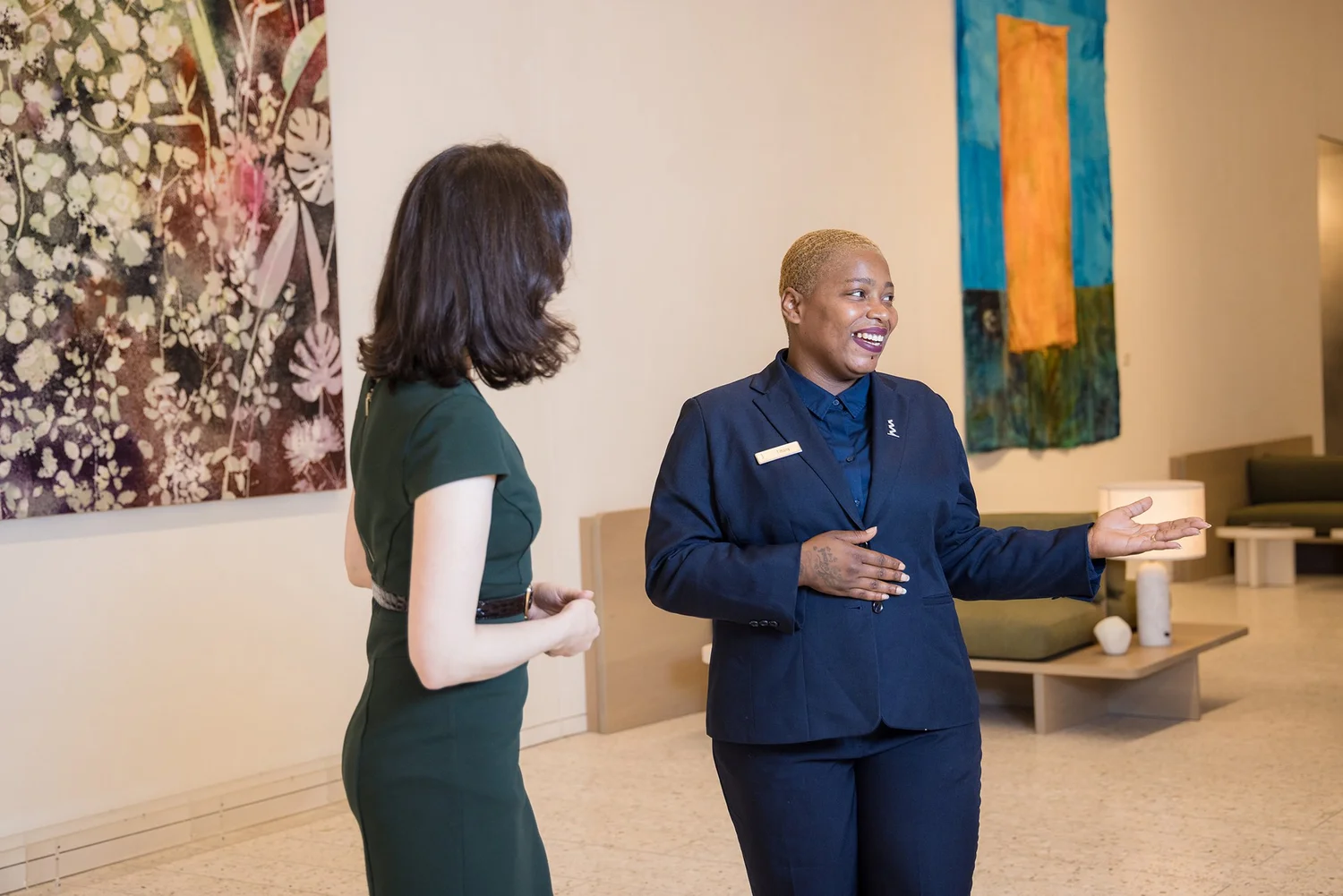 Corporate branding photo of a concierge welcoming a guest in an art-filled Manhattan office lobby
