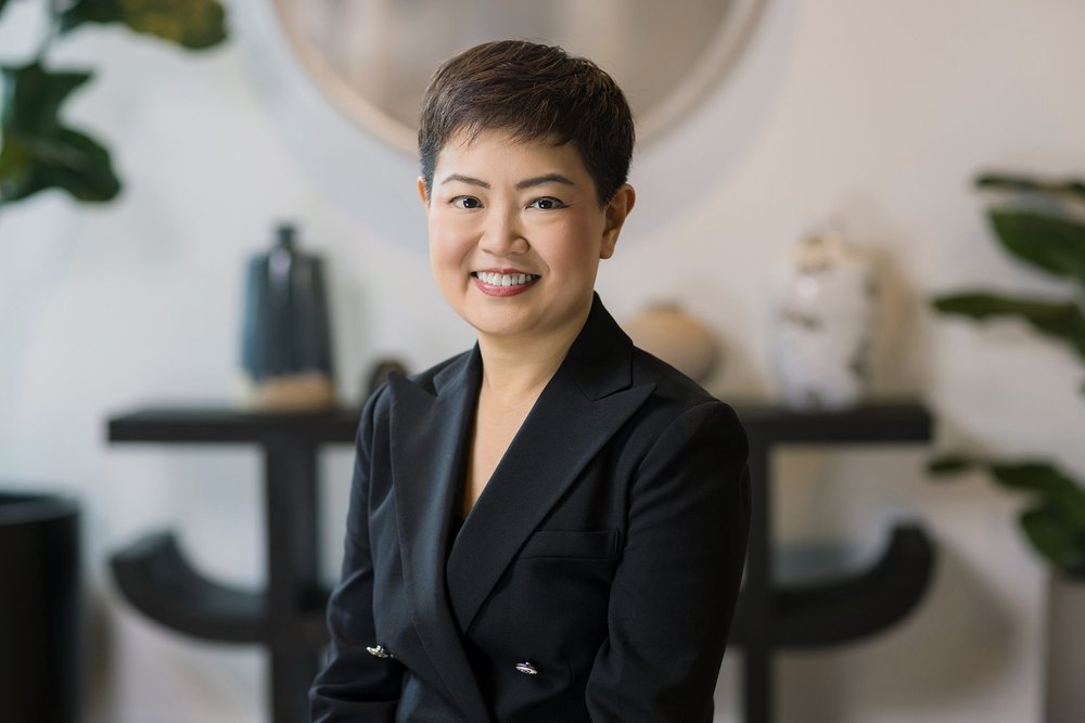 Environmental corporate portrait of a woman in a black blazer in a modern interior