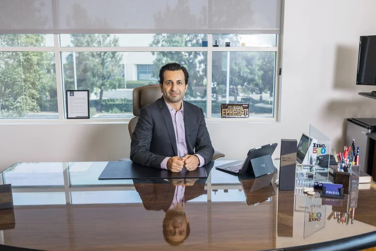 Software CEO portrait seated at his desk in a bright corner office