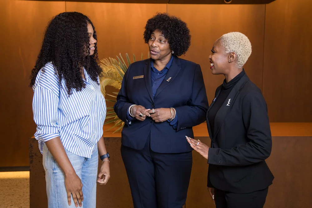 Three women talking and smiling during a corporate branding session in New York