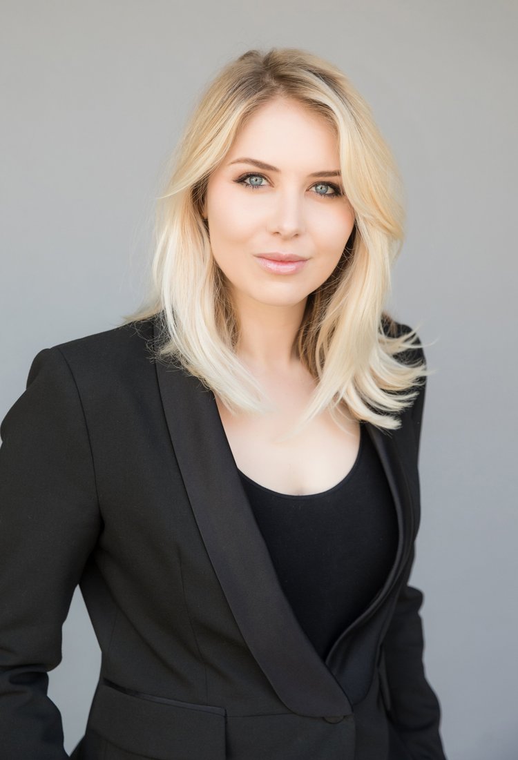 Modern headshot of a young real estate professional with platinum blonde hair in a black blazer