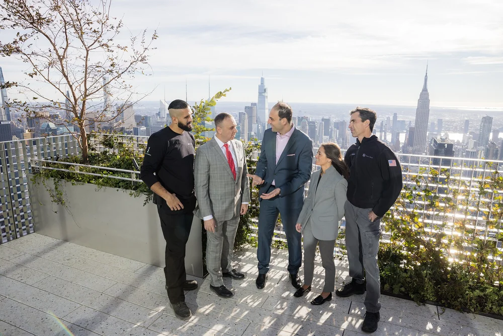 Real estate team meeting on a Manhattan rooftop with the Empire State Building in the background