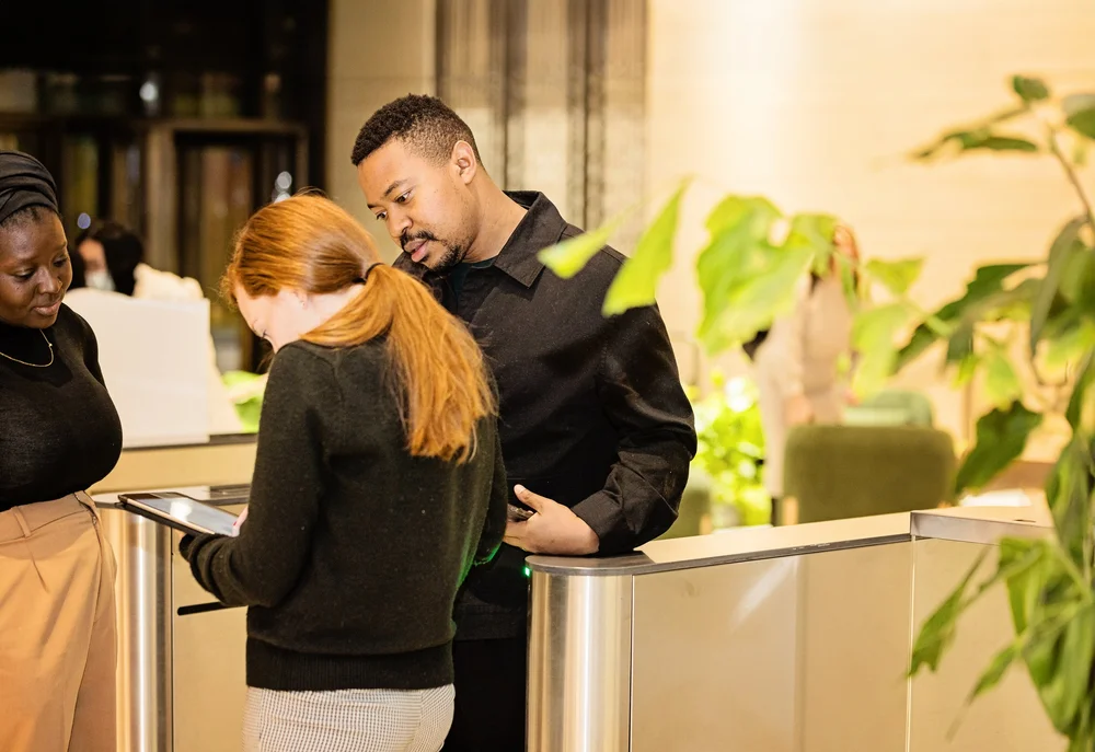Three hotel team members at a warmly lit reception desk