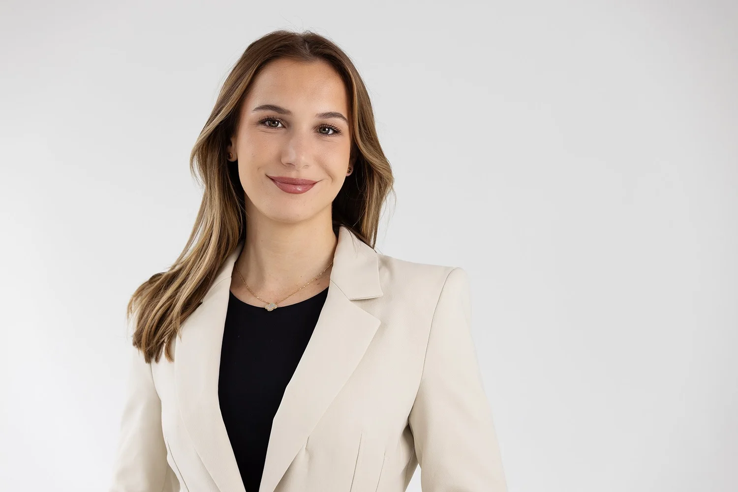 Corporate headshot of a New York professional woman in a cream blazer, photographed by Blue Sky's Studio