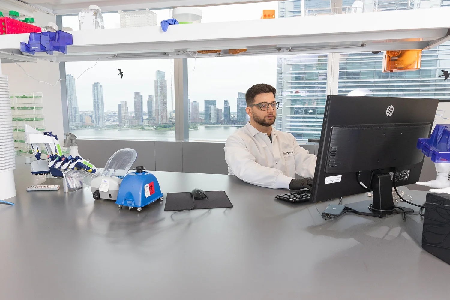 MedTech scientist in a lab coat in a modern lab with a skyline view