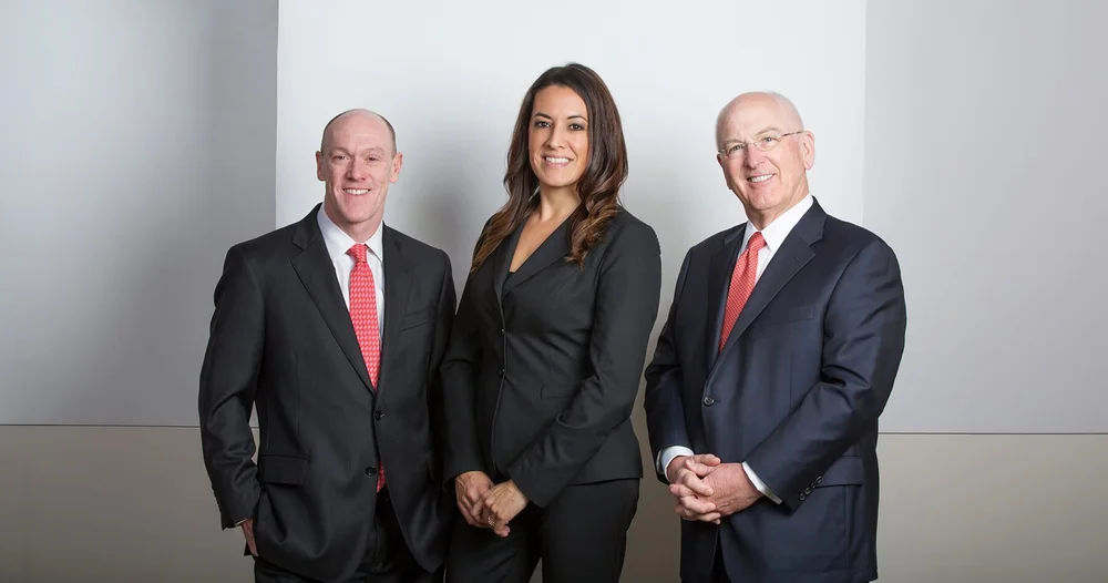 Leadership portrait of three consulting firm partners in dark suits