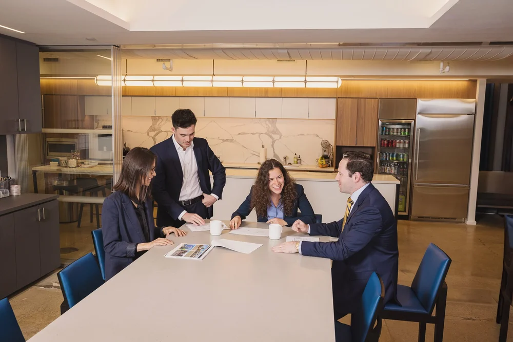 Four colleagues sharing a laugh during a meeting for a corporate business photo shoot