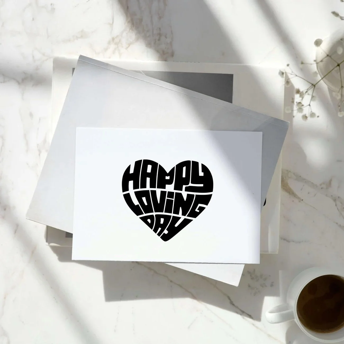 The words Loving Day in black in the shape of a heart, on marble tabel