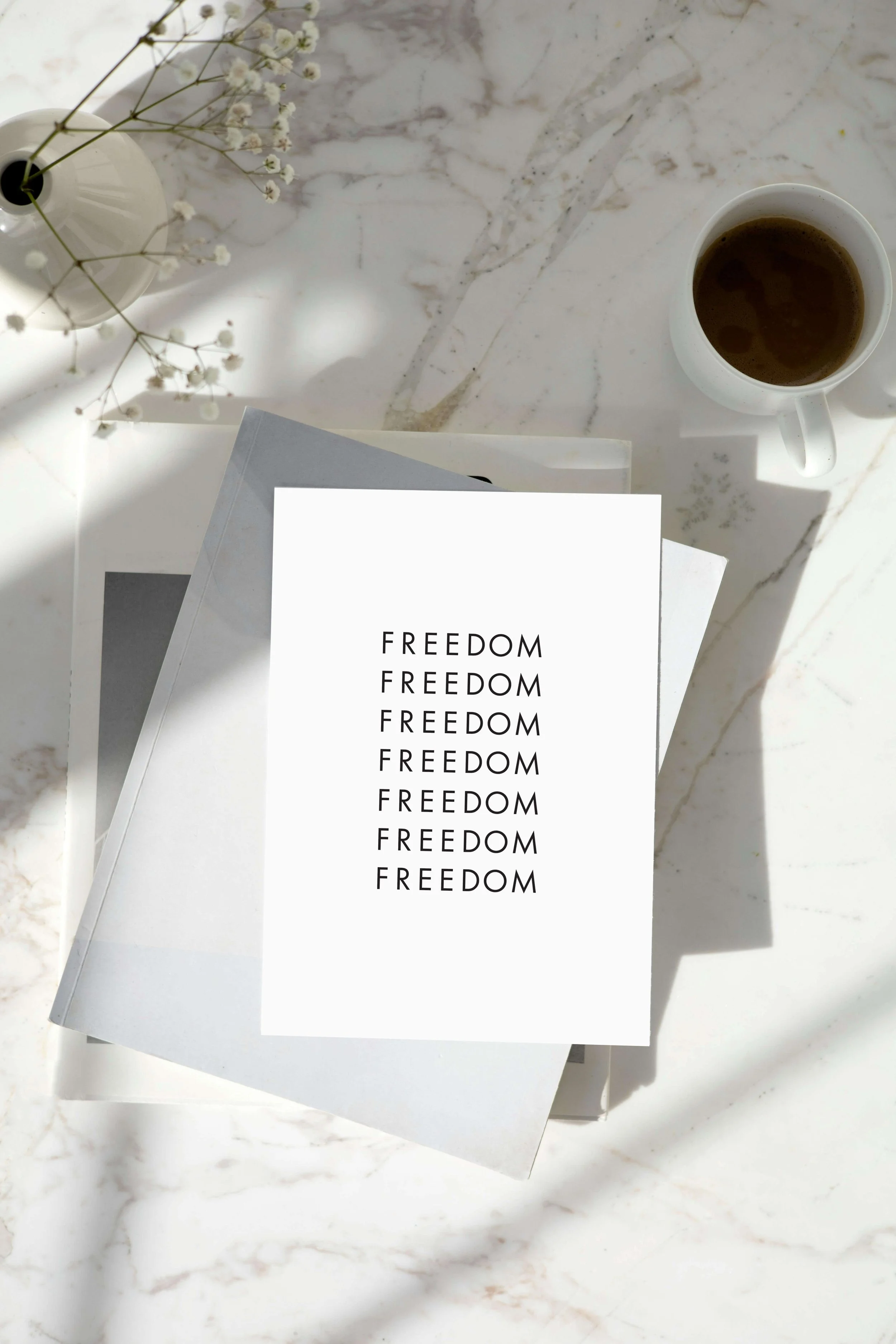 Juneteenth greeting card, that reads "Freedom". On marble table with coffee.
