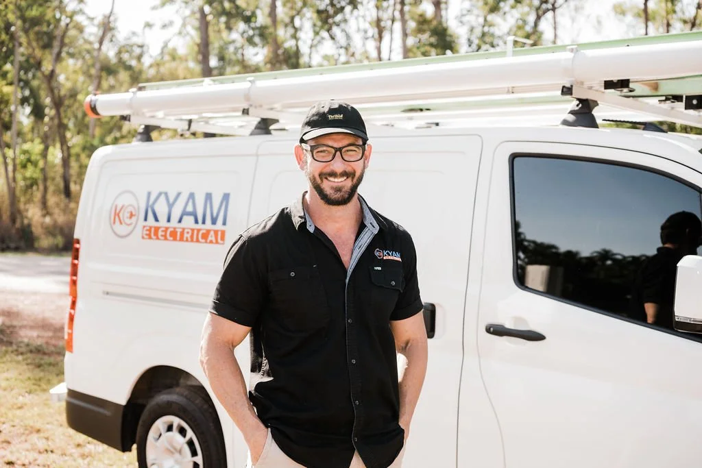 Kyam electrician standing in front of van