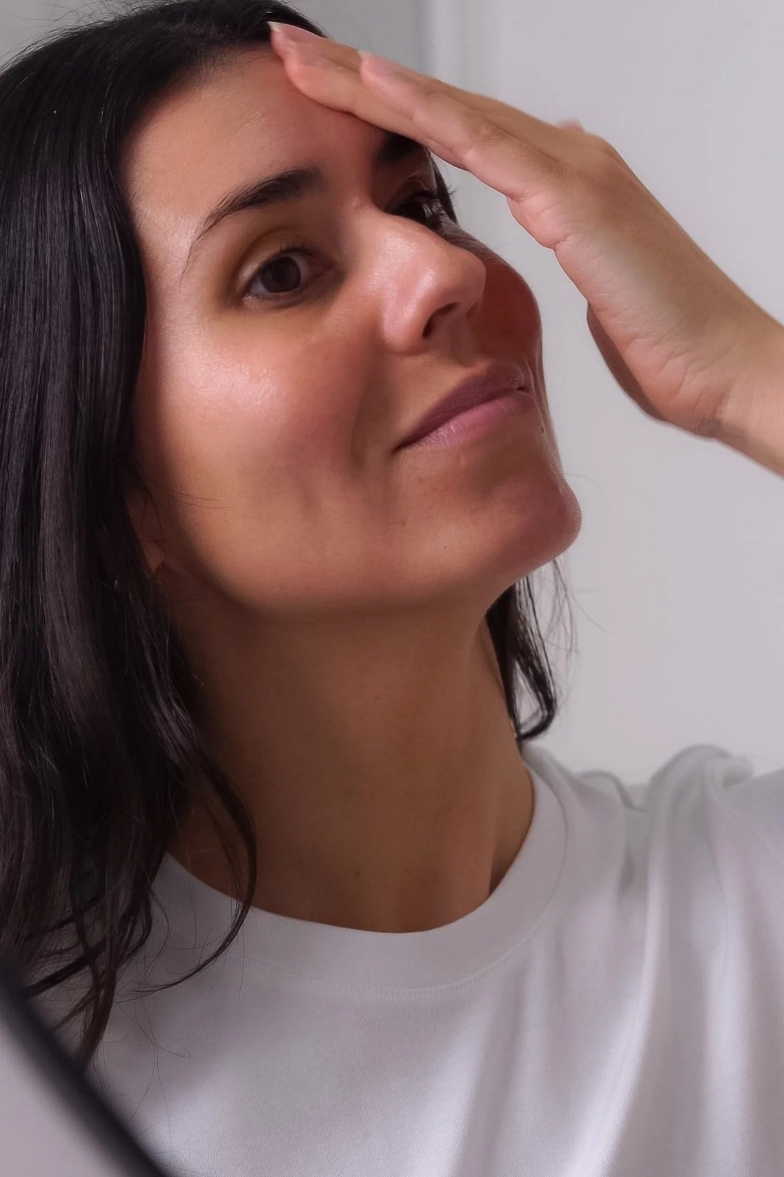 Woman applying moisturiser to nourish dry and sensitive skin during winter.