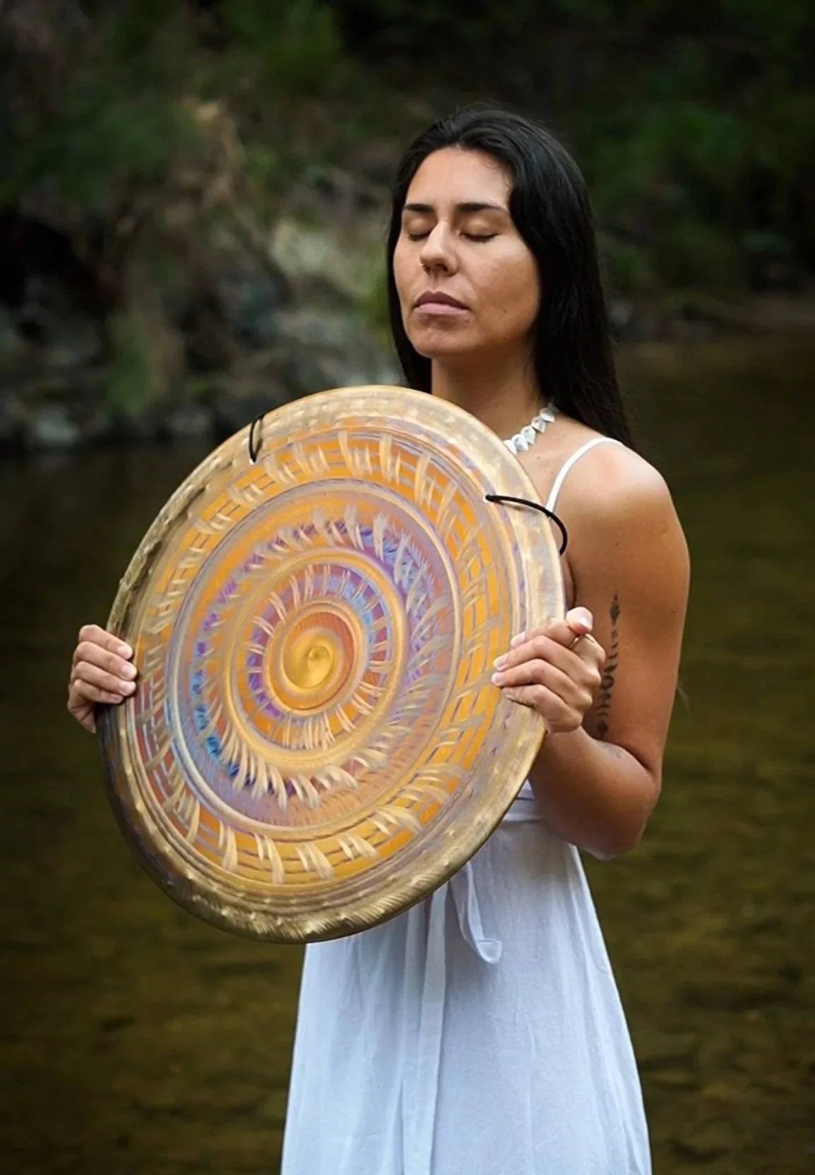 Woman holding a gong, representing Lawen’s holistic healing and organic skincare rituals.