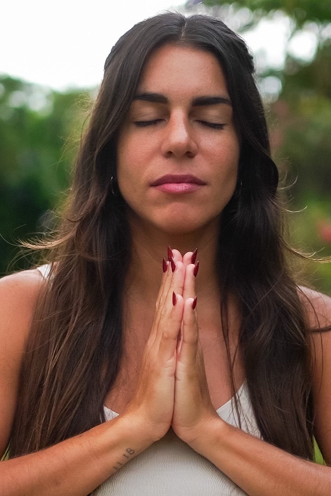 Woman in nature meditating, embracing Lawen’s holistic approach to organic skincare rituals.