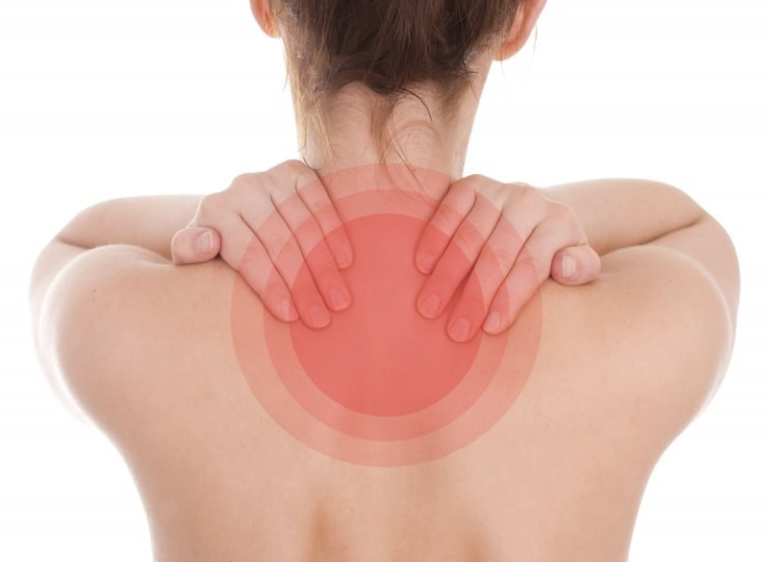 Person with shoulder and neck pain, holding neck with both hands, with a red target circle indicating pain area on back of neck